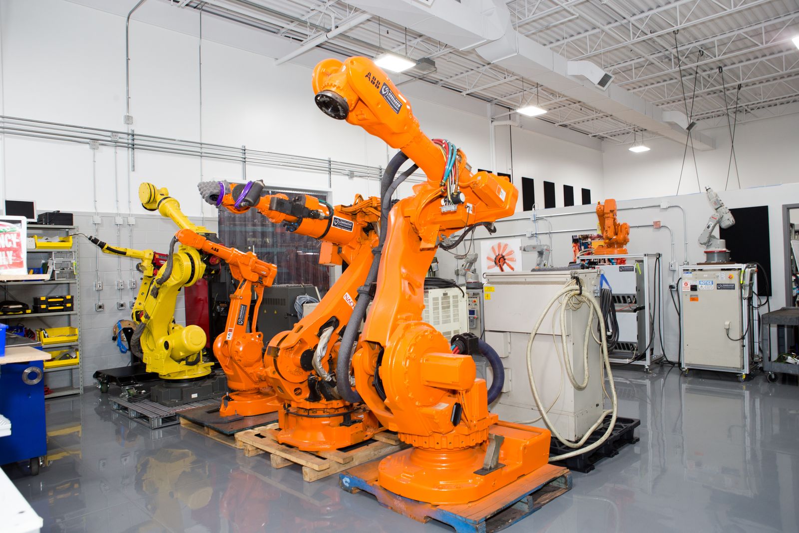 ABB, FANUC and Nachi industrial robots with their controllers on the AST robotics shop floor